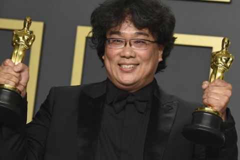 Bong Joon Ho poses in the press room with the awards for best director for "Parasite" and for best international feature film for "Parasite" from South Korea at the Oscars on Sunday, Feb. 9, 2020, at the Dolby Theatre in Los Angeles. (Photo by Jordan Strauss/Invision/AP)
