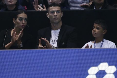 Cristiano Ronaldo, center, with his partner Georgina Rodriguez, and his son Cristiano Ronaldo Jr watches as Novak Djokovic of Serbia plays John Isner of the United States in their ATP World Tour Finals singles tennis match at the O2 Arena in London, Monday Nov. 12, 2018. (AP Photo/Tim Ireland)