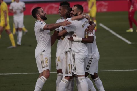 Real Madrid's Karim Benzema, right, celebrates with his teammates after scoring during the Spanish La Liga soccer match between Real Madrid and Villareal at the Alfredo di Stefano stadium in Madrid, Spain, Thursday, July 16, 2020. (AP Photo/Bernat Armangue)
