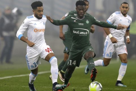 Marseille's Jordan Amavi, left, challenges for the ball with Saint-Etienne's Jonathan Bamba during the League One soccer match between Marseille and Saint-Etienne, at the Velodrome stadium, in Marseille, southern France, Sunday, Dec. 10, 2017. (AP Photo/Claude Paris)