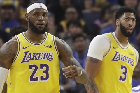 Los Angeles Lakers forward LeBron James (23) reacts in front of forward Anthony Davis (3) during the first half of a preseason NBA basketball game against the Golden State Warriors in San Francisco, Saturday, Oct. 5, 2019. (AP Photo/Jeff Chiu)