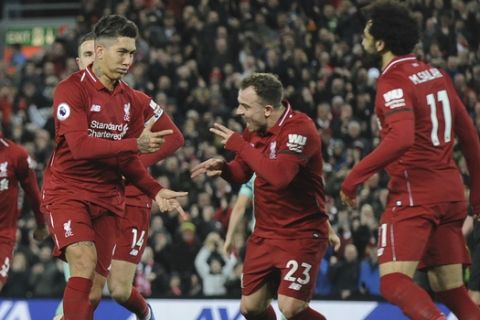 Liverpool's Roberto Firmino, left, celebrates with teammates after he scores his sides 5th goal and his 3rd from the penalty spot during the English Premier League soccer match between Liverpool and Arsenal at Anfield in Liverpool, England, Saturday, Dec. 29, 2018. (AP Photo/Rui Vieira)
