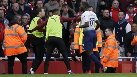 Tottenham's Moussa Sissoko, right, agrees with Arsenal's Stephan Lichtsteiner, left, after Tottenham's Harry Kane scored his side's opening goal from the penalty spot during the English Premier League soccer match between Arsenal and Tottenham Hotspur at the Emirates Stadium in London, Sunday Dec. 2, 2018. (AP Photo/Tim Ireland)