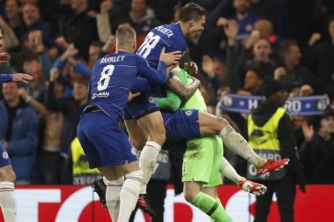 Chelsea players jump on top of goalkeeper Kept Arrizabalaga who made two saves in the penalty shootout during the Europa League semifinal second leg soccer match between FC Chelsea and Eintracht Frankfurt at Stamford Bridge stadium in London, Thursday, May 9, 2019. Chelsea won the shootout and will play the final. (AP Photo/Alastair Grant)