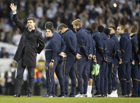 Tottenham's manager Mauricio Pochettino waves to fans as he stands on the pitch with current Tottenham players during a final ceremony on the pitch after the last match played at the ground, the English Premier League soccer match between Tottenham Hotspur and Manchester United at White Hart Lane stadium in London, Sunday, May 14, 2017. It was the last Spurs match at the old stadium, a new stadium is being built on the site. (AP Photo/Frank Augstein)