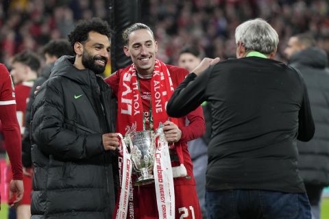 Liverpool's Mohamed Salah and Liverpool's Kostas Tsimikas pose with the trophy after winning the English League Cup final soccer match between Chelsea and Liverpool at Wembley Stadium in London, Sunday, Feb. 25, 2024. (AP Photo/Alastair Grant)