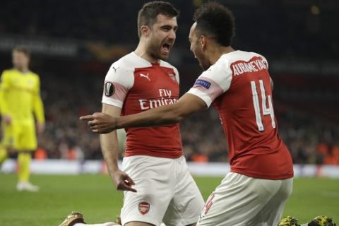 Arsenal's Sokratis Papastathopoulos, left, celebrates with Arsenal's Pierre-Emerick Aubameyang after scoring his side's third goal during the Europa League round of 32 second leg soccer match between Arsenal and Bate at the Emirates stadium in London, Thursday, Feb. 21, 2019. (AP Photo/Matt Dunham)