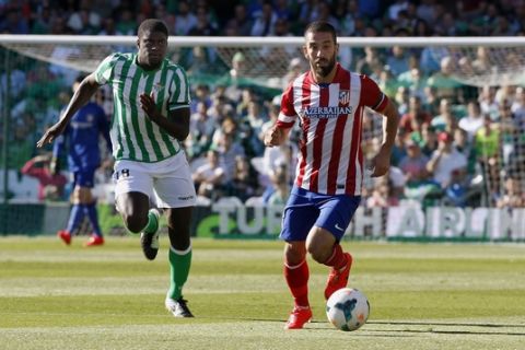Atletico de Madrid's Arda Turan, right, and Betis' Alfred N'Diaye, left, vie for the ball during their La Liga soccer match at the Benito Villamarin stadium, in Seville, Spain on Sunday, March 23, 2014. (AP Photo/Angel Fernandez)
