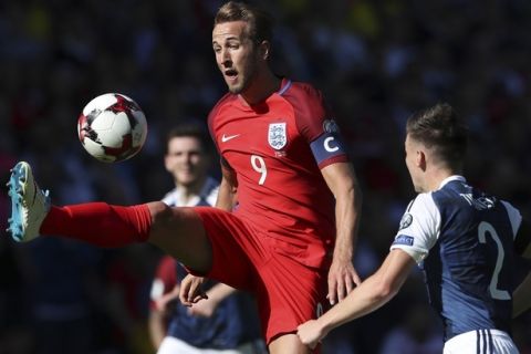 England's Harry Kane, left, view for the ball next to Scotland's Charlie Tierney during the World Cup Group F qualifying soccer match between Scotland and England at Hampden Park, Glasgow, Scotland, Saturday, June 10, 2017. (AP Photo/Scott Heppell)