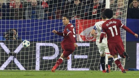 Liverpool's Roberto Firmino, left, scores his side's third goal during a Champions League group E soccer match between Sevilla and Liverpool, at the Ramon Sanchez Pizjuan stadium in Seville, Spain, Tuesday, Nov. 21, 2017. (AP Photo/Miguel Morenatti)