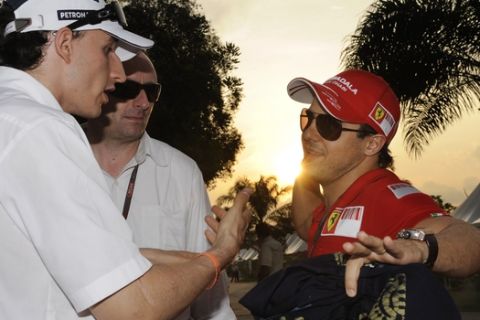 Ferrari Formula One driver Felipe Massa of Brazil, right, and BMW Sauber Formula One driver Robert Kubica of Poland, have a chat in the sunset three days prior to the Malaysian Formula One Grand Prix at the Sepang racetrack in Kuala Lumpur, Malaysia, Thursday, April 2, 2009. The second Grand Prix of the season will be held here on Sunday, April 5, 2009. (AP Photo/Oliver Multhaup)