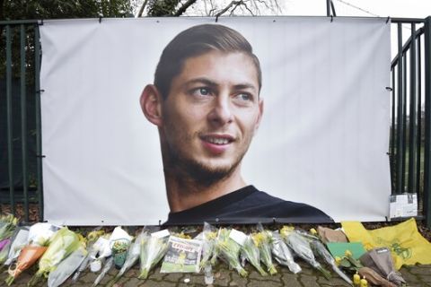 Flowers and tributes are placed near a giant picture of Argentine soccer player Emiliano Sala outside the FC Nantes training camp, in Nantes, western France, Thursday, Jan. 24, 2019, after a plane with Sala on board went missing over the English Channel on Monday night. Sobbing after the active search for her brother was halted, the sister of Argentine soccer player Emiliano Sala urged authorities Thursday not to give up trying to find the remains of his plane that disappeared from radar over the English Channel. (AP Photo)