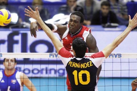 Cuba's Robertlandy Simon Aties, facing the camera, spikes the ball as Spain's Jorge Fernandez tries to block him during a third round match between Cuba and Spain, at the Men's Volleyball World Championships, in Florence, Italy, Tuesday, Oct. 5, 2010. (AP Photo/Fabrizio Giovannozzi)