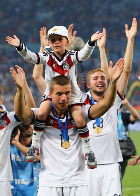RIO DE JANEIRO, BRAZIL - JULY 13: Lukas Podolski of Germany and his son Louis Podolski celebrate after defeating Argentina 1-0 in extra time during the 2014 FIFA World Cup Brazil Final match between Germany and Argentina at Maracana on July 13, 2014 in Rio de Janeiro, Brazil.  (Photo by Martin Rose/Getty Images)