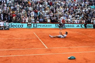 (FILES) This file picture taken on June 10, 2001 shows Brazilian Gustavo Kuerten lying down in the center of a heart he drew on the court to celebrate his win in the men's singles final at the French Tennis Open in Roland Garros, Paris. Kuerten will play his last competition in 2008 at his home away from home, Roland Garros. Three-time French Open winner, "Guga" won the hearts of Paris public for good in 2001 for a spontaneous gesture at the end of an extraordinary fourth round tie against American Michael Russell when he sunk to his knees and traced a huge heart with his racket on the red clay to dedicate his win to the fans in the stands. AFP PHOTO/FILES/JACQUES DEMARTHON TO GO WITH AFP STORY BY ALLAN KELLY (Photo credit should read JACQUES DEMARTHON/AFP/Getty Images)