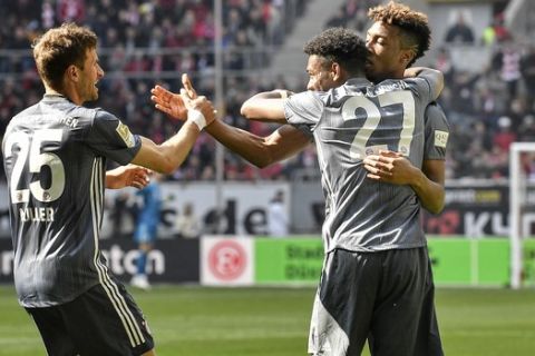 Bayern's Thomas Mueller, David Alaba and Kingsley Coman, from left, celebrate their opening goal during the German Bundesliga soccer match between Fortuna Duesseldorf and Bayern Munich in Duesseldorf, Germany, Sunday April 14, 2019. (AP Photo/Martin Meissner)