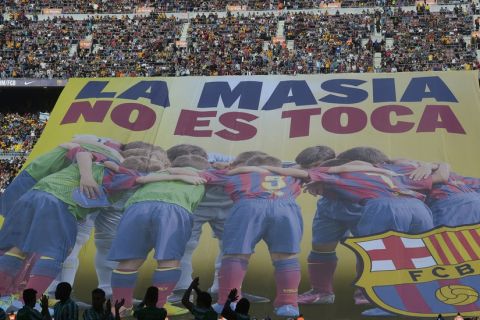 FC Barcelona's supporters unveil a giant banner reading in Catalan 'La Masia, don't touch it' prior to the Spanish La Liga soccer match between FC Barcelona and Betis at the Camp Nou stadium in Barcelona, Spain, Saturday, April 5, 2014. Barcelona has been "the victim of a grave injustice" after being hit with a FIFA transfer ban, Josep Maria Bartomeu said on Thursday as the Spanish champion vowed not to change its model for recruiting youth players. Bartomeu told a news conference the club has never broken any Spanish regulations in signing young talents to its famed La Masia academy, which has produced such players as Lionel Messi, Xavi Hernandez, and Andres Iniesta. (AP Photo/Manu Fernandez)