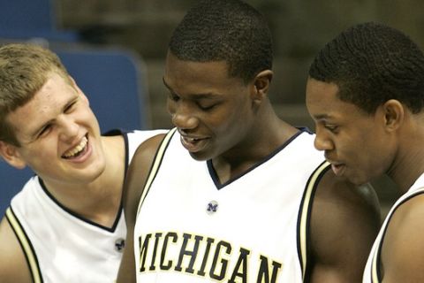University of Michigan basketball players Zack Gibson, from left, Kendric Price, and Jevohn Shepherd laugh while looking at the media guide during media day in Ann Arbor, Mich., Wednesday, Oct. 11, 2006. (AP Photo/Paul Sancya)
