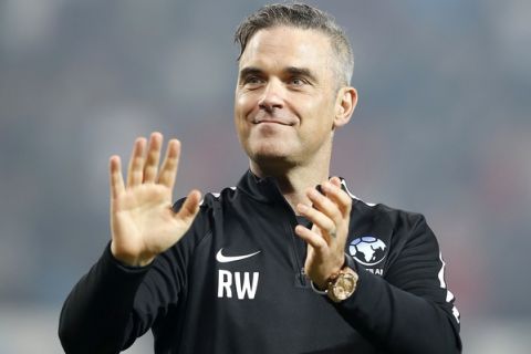 England's Robbie Williams acknowledges fans after the final whistle during the UNICEF Soccer Aid match at Old Trafford, Manchester, Sunday June 10, 2018.   (Martin Rickett/PA via AP)