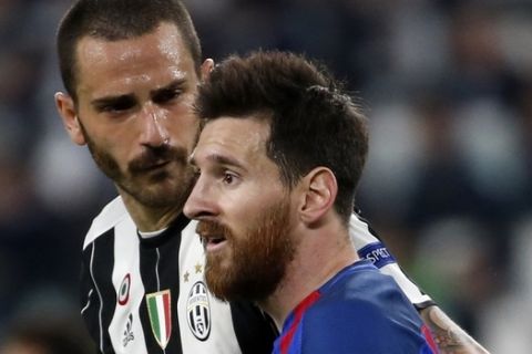 Juventus' Leonardo Bonucci, left, faces Barcelona's Lionel Messi during a Champions League, quarterfinal, first-leg soccer match between Juventus and Barcelona, at the Juventus Stadium in Turin, Italy, Tuesday, April 11, 2017. (AP Photo/Antonio Calanni)