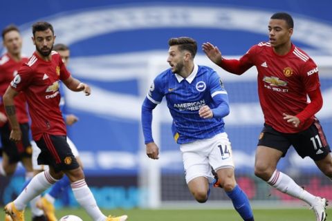 Brighton's Adam Lallana, center, holds off a challenge by Manchester United's Mason Greenwood, right, during the English Premier League soccer match between Brighton Hove Albion and Manchester United in Brighton, England, Saturday, Sept. 26, 2020. (John Sibley/Pool via AP)