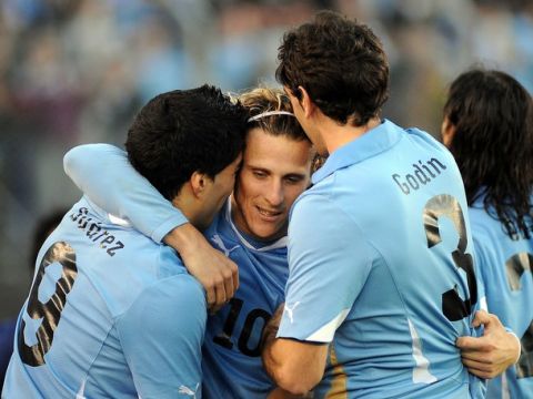 Uruguay's Diego Forlan is congratulated by his temmates Luis Suarez and Diego Gopdin after scoring the 3rd goal of his team during the final of the 2011 Copa America football tournament held at the Monumental stadium in Buenos Aires, on July 24, 2011.  AFP PHOTO / SERGIO GOYA (Photo credit should read SERGIO GOYA/AFP/Getty Images)