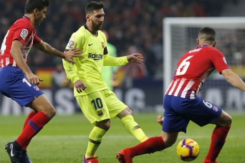 Barcelona's Lionel Messi, center, kicks the ball during a Spanish La Liga soccer match between Atletico Madrid and FC Barcelona at the Metropolitano stadium in Madrid, Saturday, Nov. 24, 2018. (AP Photo/Paul White)