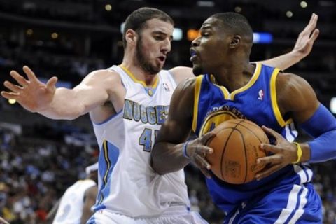 Denver Nuggets center Kosta Koufas, left, guards Golden State Warriors forward Jeff Adrien in the fourth quarter of an NBA basketball game in Denver on Monday, April 11, 2011. The Nuggets won 134-111. (AP Photo/Chris Schneider)