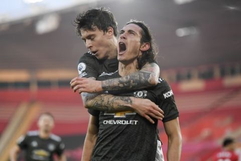 Manchester United's Edinson Cavani, right, celebrates with Victor Lindelof after scoring his side's second goal during an English Premier League soccer match between Southampton and Manchester United at the St. Mary's stadium in Southampton, England, Sunday, Nov. 29, 2020. (Mike Hewitt, Pool via AP)