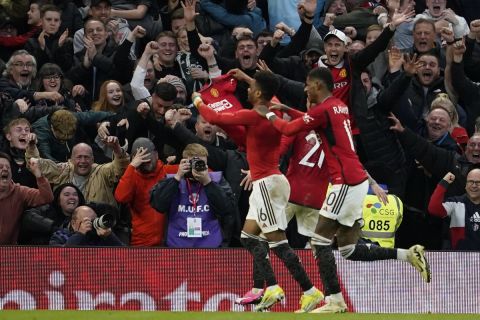Manchester United's Amad Diallo, left, celebrates after scoring his side's fourth goal during the FA Cup quarterfinal soccer match between Manchester United and Liverpool at the Old Trafford stadium in Manchester, England, Sunday, March 17, 2024. (AP Photo/Dave Thompson)