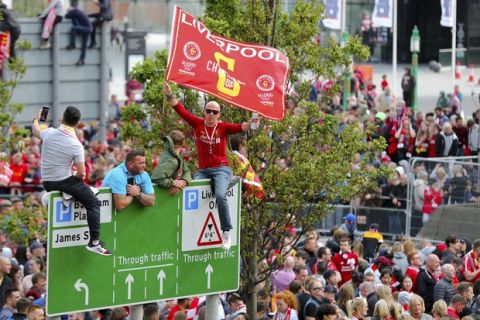 Fans gain vantage points to watch as Liverpool soccer team ride an open top bus during the Champions League Cup Winners Parade through the streets of Liverpool, England, Sunday June 2, 2019.  Liverpool is champion of Europe for a sixth time after beating Tottenham 2-0 in the Champions League final played in Madrid Saturday. (Richard Sellers/PA via AP)