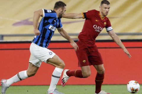 Roma's Edin Dzeko, right, and Inter Milan's Stefan de Vrij challenge for the ball during the Serie A soccer match between Roma and Inter Milan, at the Rome Olympic Stadium, Sunday, July 19, 2020. (AP Photo/Riccardo De Luca)