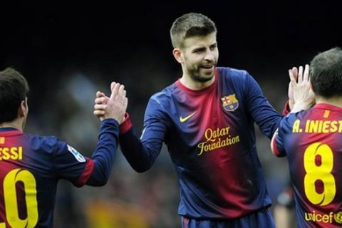FC Barcelona's Gerard Pique, center, celebrates a goal with his teammates Lionel Messi from Argentina, left, and Andres Iniesta, right, during a Spanish La Liga soccer match against Getafe, at the Camp Nou stadium in Barcelona, Spain, Sunday, Feb. 10, 2013. (AP Photo/Manu Fernandez)