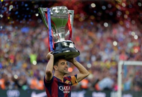FC Barcelona's Xavi Hernandez holds up the trophy after winning the Spanish League title, at the end of their Spanish La Liga last round soccer match against Deportivo Coruna at the Camp Nou stadium in Barcelona, Spain, Saturday, May 23, 2015. (AP Photo/Manu Fernandez)