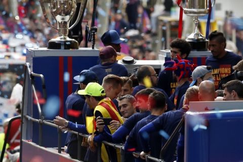 Barcelona coach Ernesto Valverde, center, takes pictures from a bus with players celebrating during a street parade in Barcelona, Spain, Monday April 30, 2018, after winning the Spanish La Liga soccer title. Barcelona clinched the 2017/18 Spanish soccer league title after a 4-2 win at Deportivo La Coruna on Sunday. (AP Photo/Manu Fernandez)