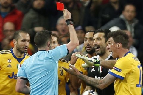 Referee Michael Oliver shows a red car to Juventus goalkeeper Gianluigi Buffon during a Champions League quarter final second leg soccer match between Real Madrid and Juventus at the Santiago Bernabeu stadium in Madrid, Wednesday, April 11, 2018. (AP Photo/Francisco Seco)