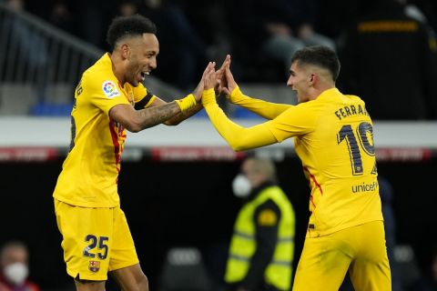 Barcelona's Pierre-Emerick Aubameyang, left, celebrates with Ferran Torres after scoring his side's fourth goal during a Spanish La Liga soccer match between Rial Madrid and FC Barcelona at the Santiago Bernabeu stadium in Madrid, Spain, Sunday, March 20, 2022. (AP Photo/Manu Fernandez)