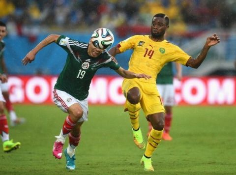 NATAL, BRAZIL - JUNE 13:  Oribe Peralta of Mexico controls the ball against Aurelien Chedjou of Cameroon during the 2014 FIFA World Cup Brazil Group A match between Mexico and Cameroon at Estadio das Dunas on June 13, 2014 in Natal, Brazil.  (Photo by Matthias Hangst/Getty Images)