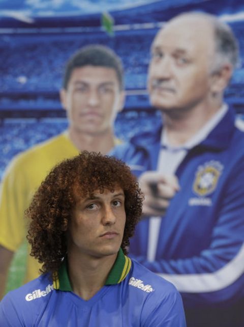 Backdropped by a picture of Brazilian coach Luiz Felipe Scolari, Brazilian soccer player David Luiz, looks on during a promotional event for Gillette in Sao Paulo, Brazil, Tuesday, May 20, 2014. The World Cup will open on June 12 with a match between Brazil and Croatia at the Itaquerao Stadium in Sao Paulo. (AP Photo/Andre Penner)