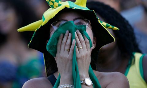 A Brazil soccer fan covers her mouth as her team is down by two goals at halftime, as she watches a live telecast of the Brazil vs. Belgium World Cup quarter finals soccer match, in Rio de Janeiro, Brazil, Friday, July 6, 2018. (AP Photo/Silvia Izquierdo)
