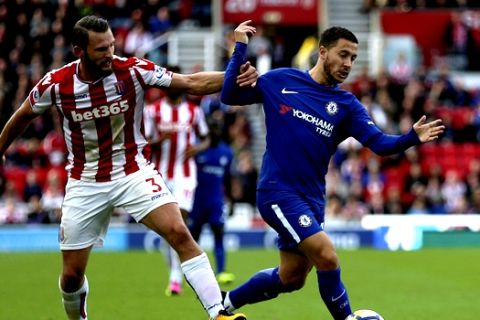 Chelsea's Eden Hazard, right, and Stoke City's Erik Pieters battle for the ball during the English Premier League soccer match between Stoke City and Chelsea at the bet365 Stadium, Stoke-on-Trent, England, Saturday, Sept. 23, 2017. (Nigel French/PA via AP)