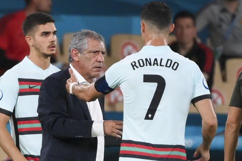 Portugal's Cristiano Ronaldo, right, gestures as he talks to Portugal's manager Fernando Santos during the Euro 2020 soccer championship round of 16 match between Belgium and Portugal at La Cartuja stadium, Seville, Spain, Sunday, June 27, 2021. (Lluis Gene/Pool Photo via AP)