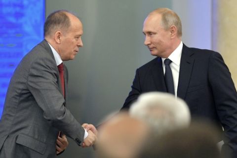 Russian President Vladimir Putin, right, shakes hands with Federal Security Service (FSB) Director Alexander Bortnikov during a meeting after the 2018 soccer World Cup in Moscow, Russia, Monday, July 16, 2018. (Alexei Druzhinin, Sputnik, Kremlin Pool Photo via AP)