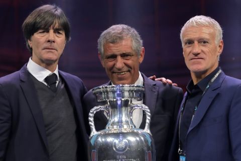 The coaches of Germany Joachim Loew, left, Portugal Fernando Santos, center, and France Didier Deschamps who will play in group F, pose with the trophy after the draw for the UEFA Euro 2020 soccer tournament finals in Bucharest, Romania, Saturday, Nov. 30, 2019. (AP Photo/Vadim Ghirda)