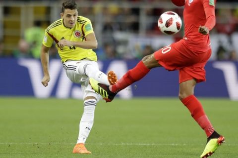 Colombia's Santiago Arias, left, kicks the ball as England's Dele Alli tries to stop him during the round of 16 match between Colombia and England at the 2018 soccer World Cup in the Spartak Stadium, in Moscow, Russia, Tuesday, July 3, 2018. (AP Photo/Matthias Schrader)