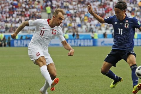Poland's Kamil Grosicki, and Japan's Takashi Usami, right, vie for the ball during the group H match between Japan and Poland at the 2018 soccer World Cup at the Volgograd Arena in Volgograd, Russia, Thursday, June 28, 2018. (AP Photo/Eugene Hoshiko)