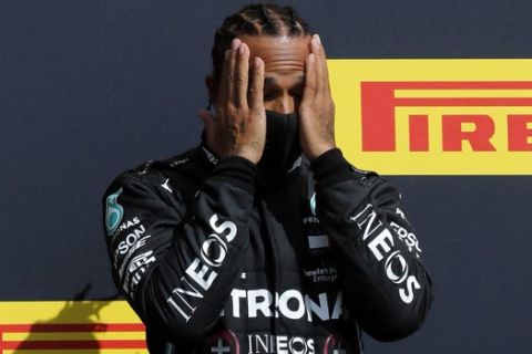 Mercedes driver Lewis Hamilton of Britain gestures at the podium after winning the British Formula One Grand Prix at the Silverstone racetrack, Silverstone, England, Sunday, Aug. 2, 2020. (AP Photo/Frank Augstein, Pool)