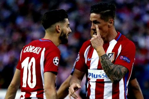 Atletico's Fernando Torres, right, speaks with teammate Yannick Carrasco during a Champions League semifinal, 2nd leg soccer match between Atletico de Madrid and Real Madrid, in Madrid, Spain, Wednesday, May 10, 2017 . (AP Photo/Daniel Ochoa de Olza)