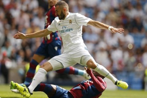 Real Madrid's Karim Benzema, top, is tackled by Levante's Jefferson Lerma during the Spanish La Liga soccer match between Real Madrid and Levante at the Santiago Bernabeu stadium in Madrid, Saturday, Sept. 9, 2017. The match ended in a 1-1 draw. (AP Photo/Francisco Seco)