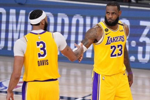 Los Angeles Lakers' Anthony Davis (3) and LeBron James (23) shake hands in the final moments of their 114-108 win over the Denver Nuggets in an NBA conference final playoff basketball game Thursday, Sept. 24, 2020, in Lake Buena Vista, Fla. (AP Photo/Mark J. Terrill)